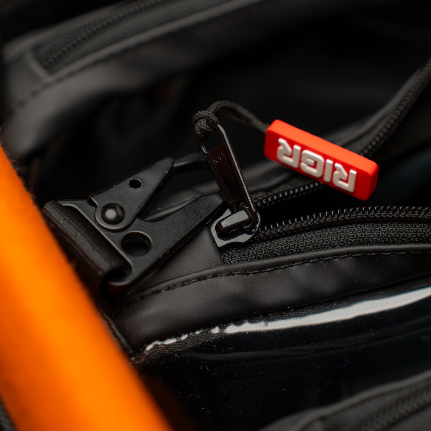 RIGR StakPak laying inside a larger camera bag, fitting neatly for portability. Showcasing zipper and army clip features.