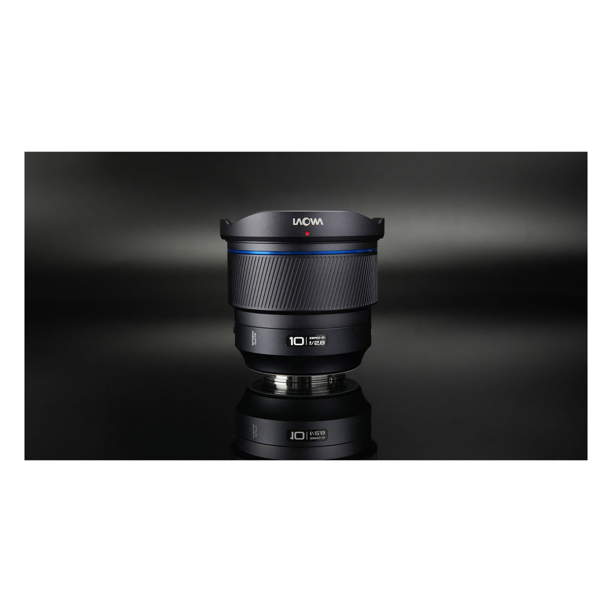Laowa 10mm f/2.8 with front cap and mount ring reflected on dark background, shot vertically.