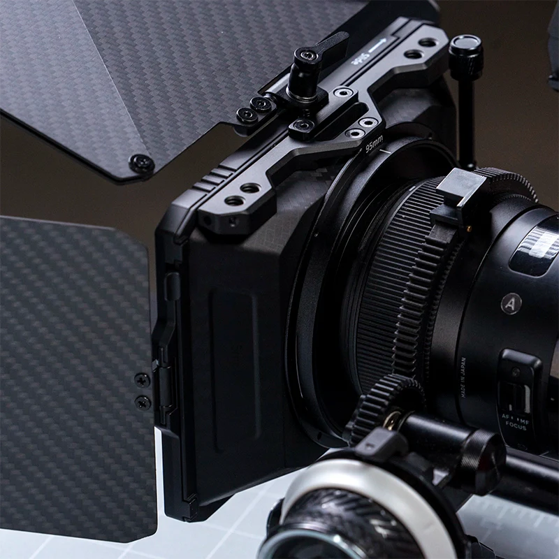 Close-up of a matte box and follow focus system mounted on a cinema camera with a carbon fibre top flag and side panels.