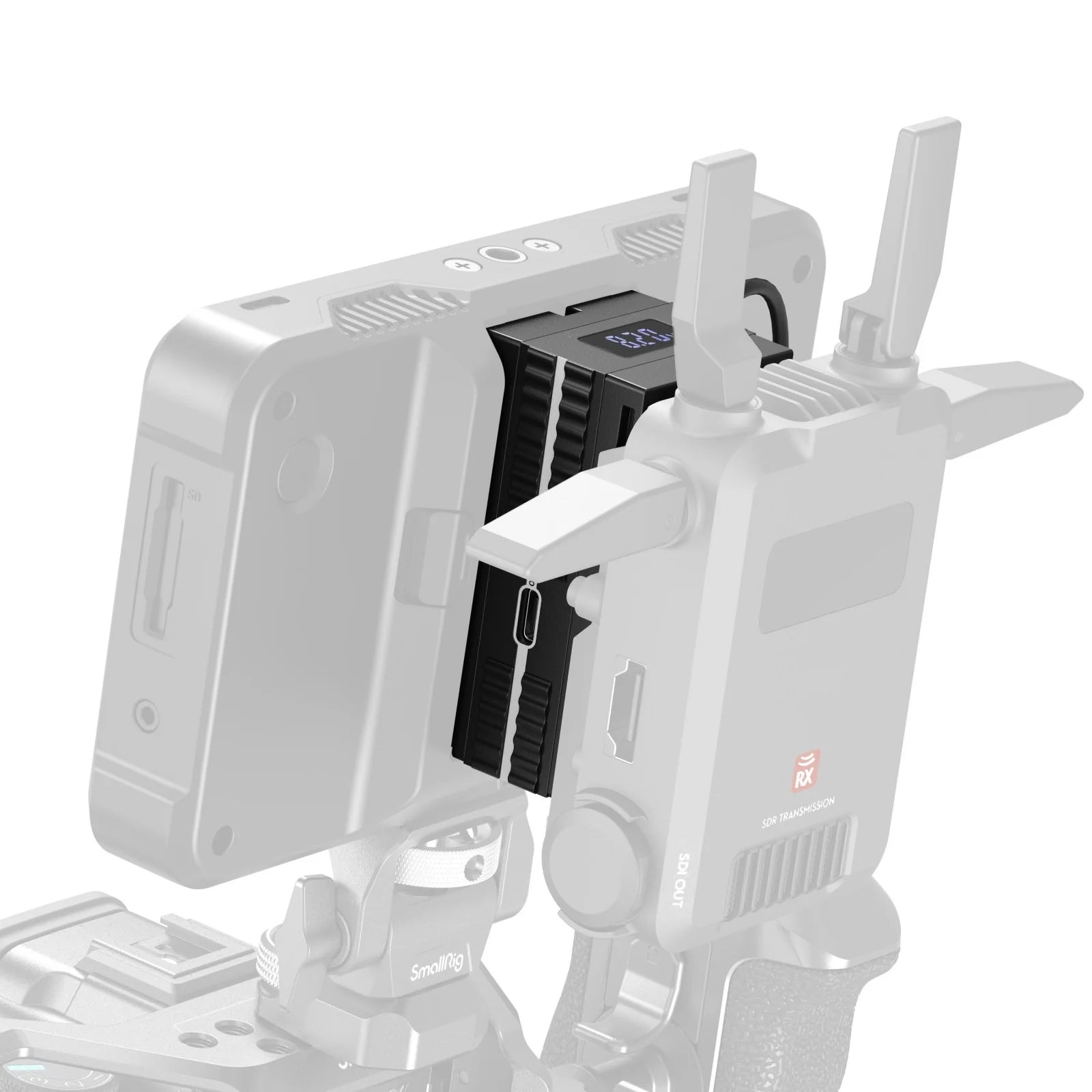 Close-up of the SmallRig dummy battery adapter mounted between a wireless video receiver and monitor.