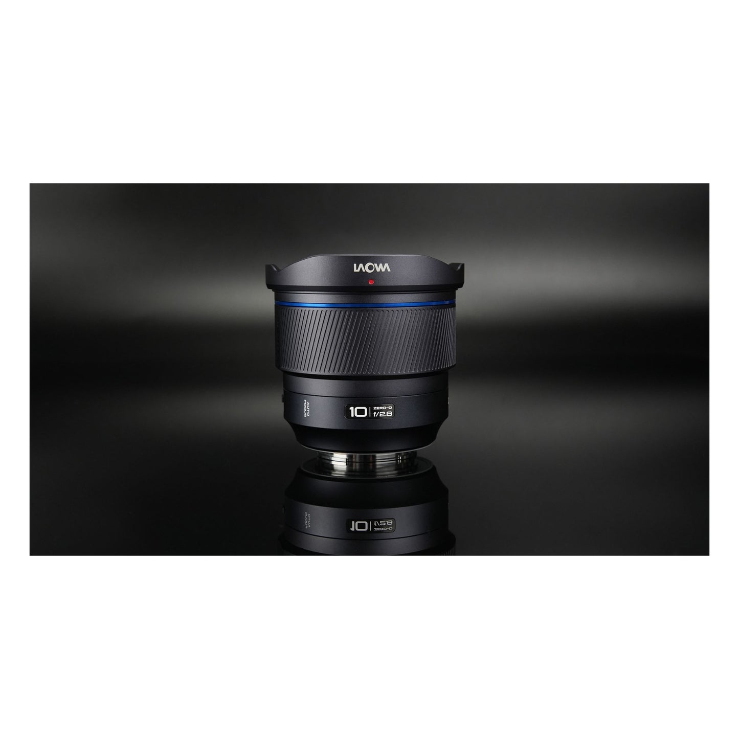Laowa 10mm f/2.8 with front cap and mount ring reflected on dark background, shot vertically.