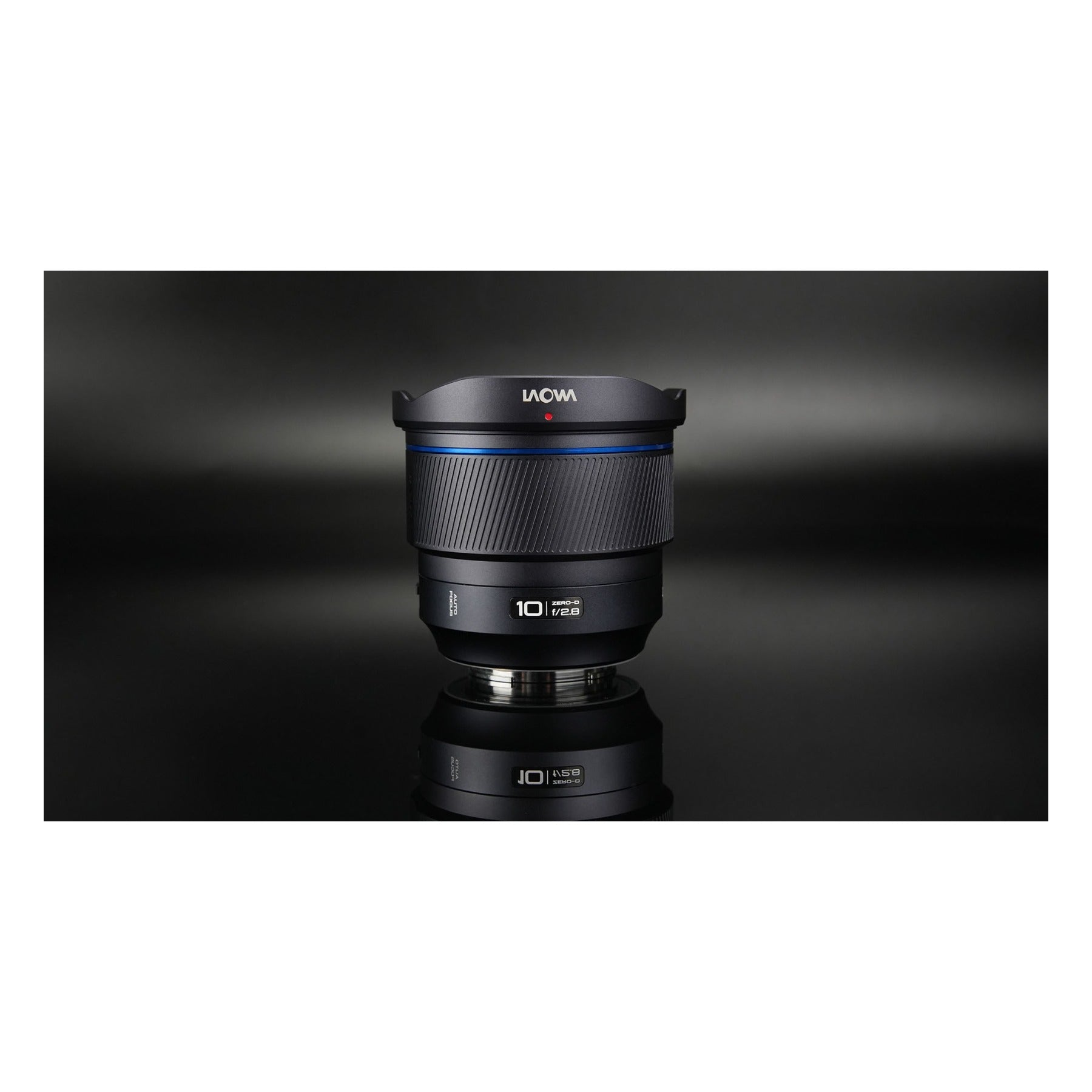 Laowa 10mm f/2.8 with front cap and mount ring reflected on dark background, shot vertically.