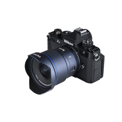 Laowa 12mm f/2.8 mounted on a Nikon Z4 mirrorless camera against white background, showing practical use context and relative size.