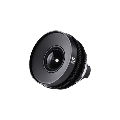 Laowa 12mm T2.9 Lite Zero-D lens from front-left angle, emphasizing the protruding front optics and ribbed focus ring detail.