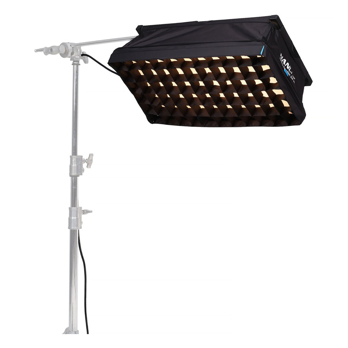PavoSlim 120B with eggcrate grid illuminated in warm (amber/gold) tone, mounted on horizontal boom arm.
