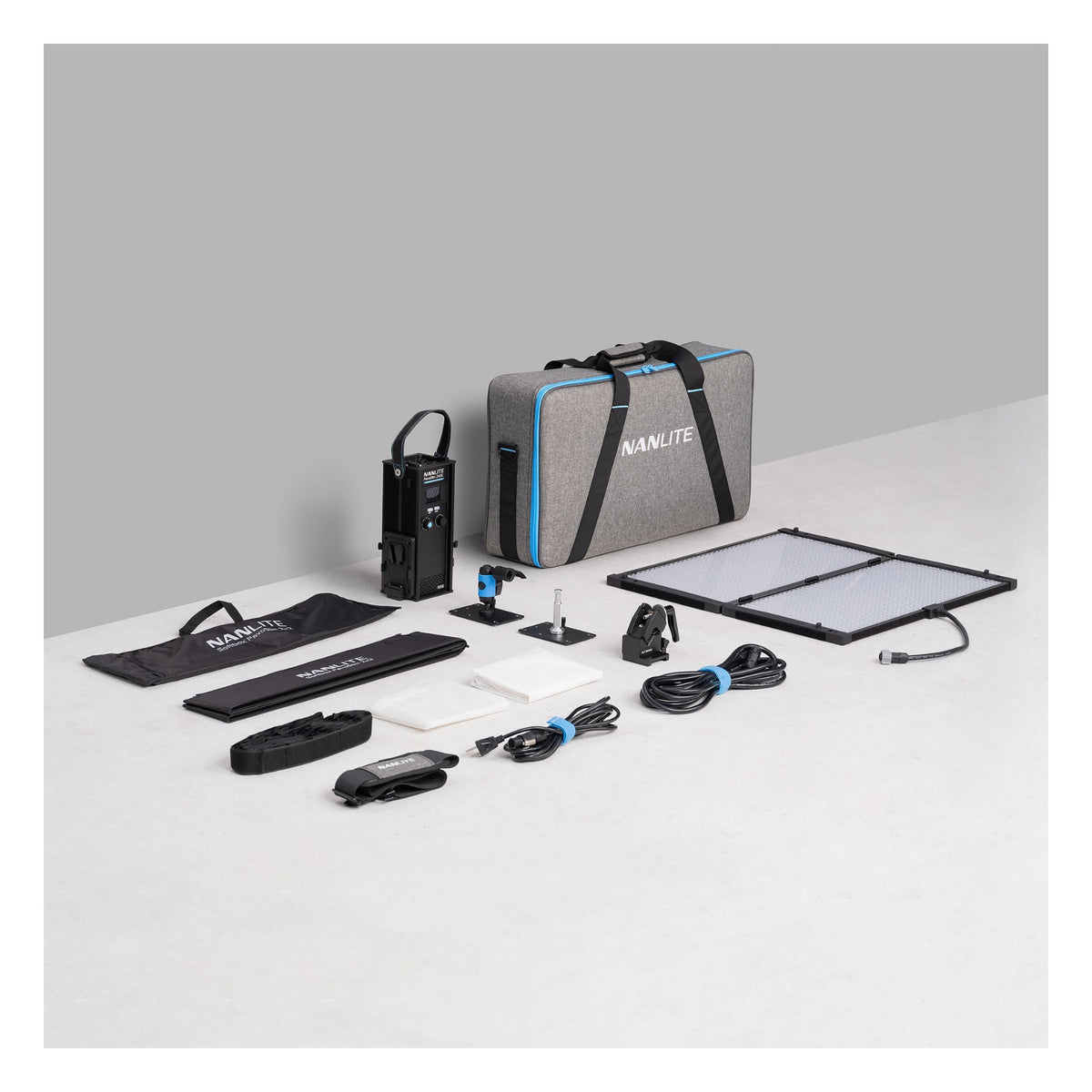 Full PavoSlim 240C kit displayed on white surface: control unit, gray padded case with blue trim, two panel sections with softbox frames, lens elements, cables, power pack, and accessories arranged for inventory reference.