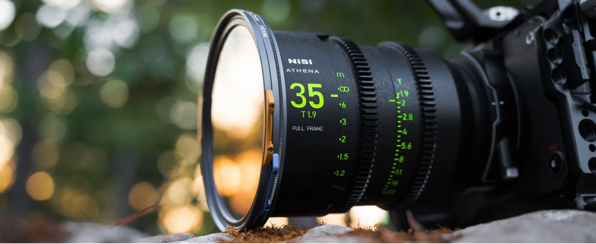 Close-up of a NiSi Athena prime cinema lens in an outdoor filmmaking environment.